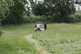 People in a field exploring Hardwick Green Meadows by Wendy Carter