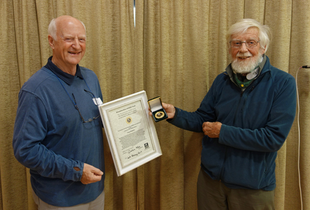 Tony Simpson (on left) receiving his Medal and certificate from Harry Green (right)