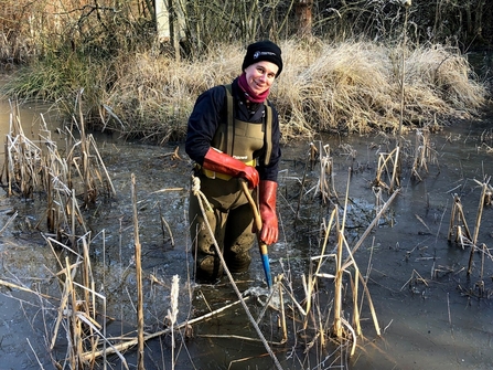Woman in chest waders in a pond in cold weather by Catharine Jarvis