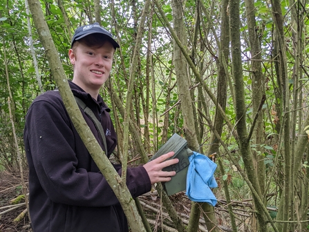 Trainee Charlie checking a dormouse box at Monkwood