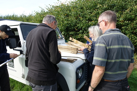 Conservation trainees and volunteers building dormouse tunnels on a Land Rover