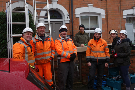 A group of people (several in high-vis clothing) standing in front of ladders after putting up a swift box by Liz Yorke