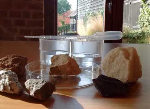 5 rocks on a table with a pipette