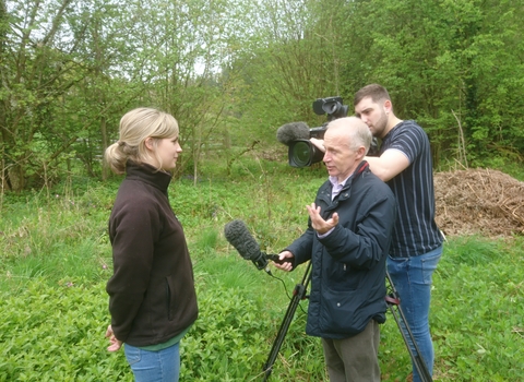 Woman being interviewed for the TV, man with microphone and second man behind a film camera by Wendy Carter