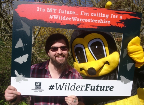 Man and person in bee costume looking through a frame calling for a #WilderFuture and a #WilderWorcestershire
