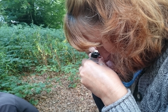 Woman looking through a hand lens by Wendy Carter