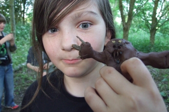 Girl holding a mud figure by Debs Richardson Bull