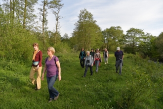 Group of people walking beside a river by Brian Taylor