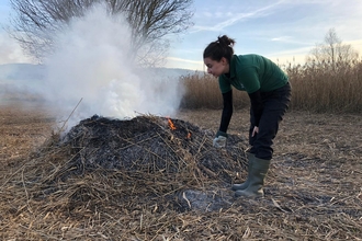 Young woman looking after a bonfire