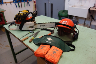 Chainsaw gear including chainsaw and protective headwear by Lydia Rackham