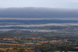 Herefordshire landscape with trees, hedges and woods with mist lying across the landscape by Wendy Carter