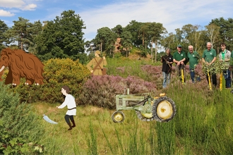 Illustration of heathland management through time - background of heathland habitat with mammoth illustration, farmer with scythe illustration, soldier with rifle illustration, tractor illustration and photo of a group of modern volunteers