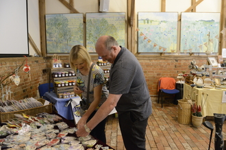 Two people looking at items on a stall at the Trust's summer craft fair