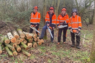 Conservation trainees stood with chainsaws