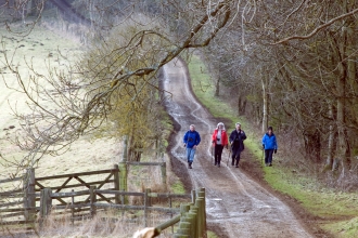 Four people walking along a track in winter by Zsuzsanna Bird