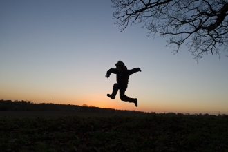 Silhouette of child playing at dusk by David Tipling/2020VISION