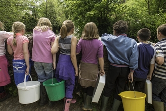 A group of children, with their backs to the camera, standing on a bridge by Ross Hoddinott/2020VISION