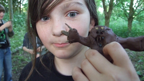 Girl holding a mud figure by Debs Richardson Bull