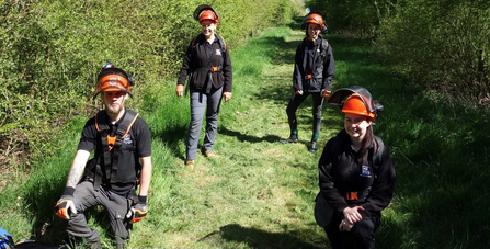 4 trainees wearing brushcutter safety helmets and posing for the camera by Iain Turbin