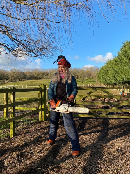 Young woman holding a chainsaw