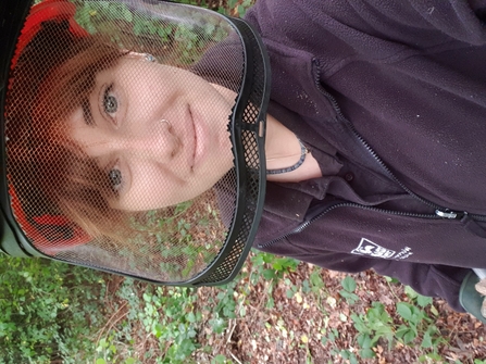 Woman looking at the camera through a face guard during coppicing
