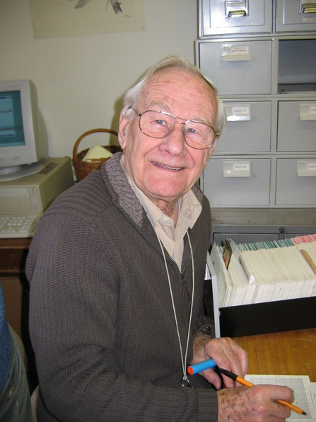 John Meiklejohn looking at the camera with filing cabinets in the background