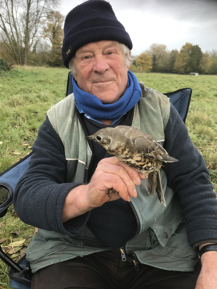Garth Lowe holding a mistle thrush