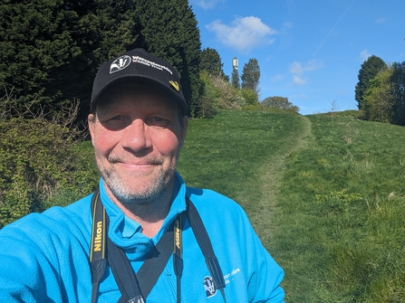 Ion Riley standing in a greenspace and smiling at the camera