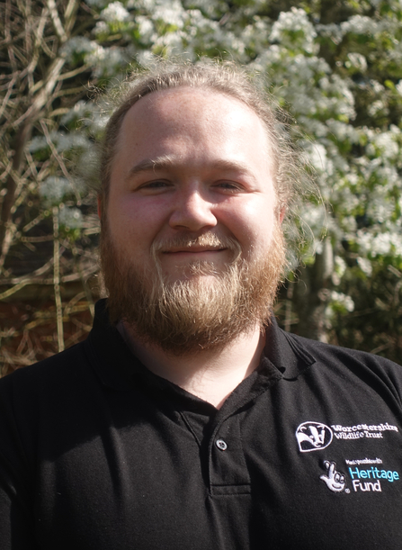 Man with beard smiling at the camera on a sunny day