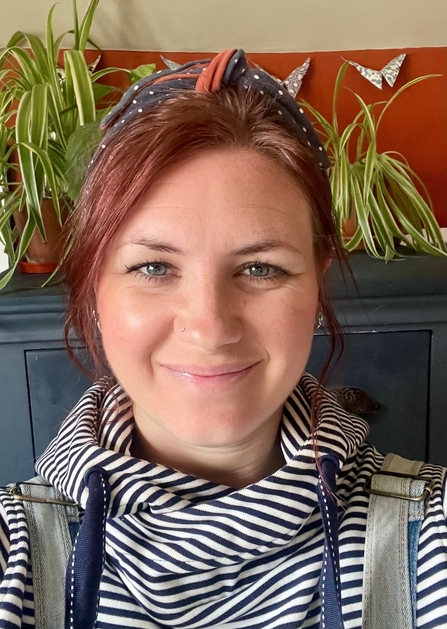 A young woman smiling at the camera - she's indoors