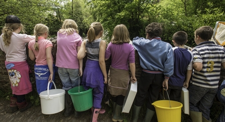A group of children, with their backs to the camera, standing on a bridge by Ross Hoddinott/2020VISION
